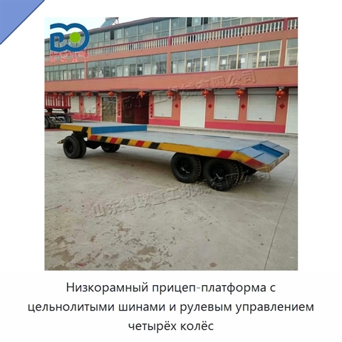 Низкорамный прицеп-платформа с цельнолитыми шинами и рулевым управлением четырёх колёс
